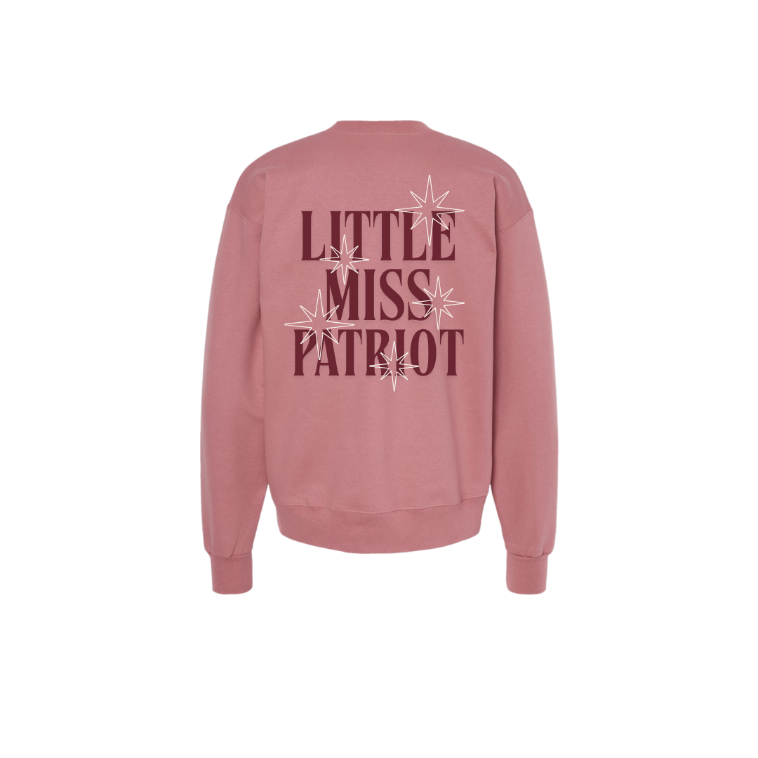 Pink crewneck with magenta letters that say Little Miss Patriot with white stars on the back. 